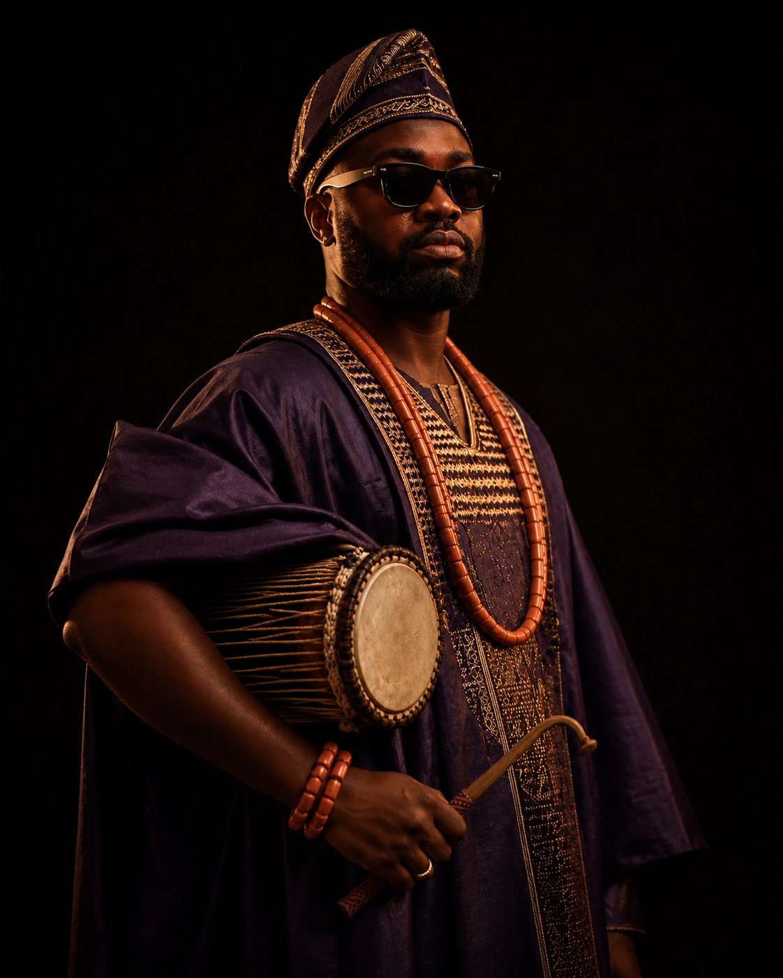 Bammixx in traditional Yoruba attire holding a Gangan talking drum